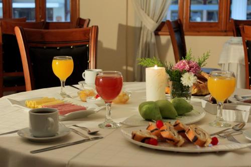 a table with a plate of food and drinks on it at Famissi Hotel in Kalabaka