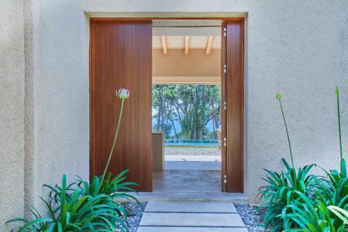 a wooden door leading into a house with plants at Pleta de Mar, Grand Luxury Hotel by Nature - Adults Only in Canyamel