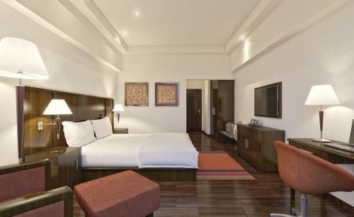 a hotel room with a bed and a desk at Regenta Central Hestia Dahej, Bhensali in Dahej
