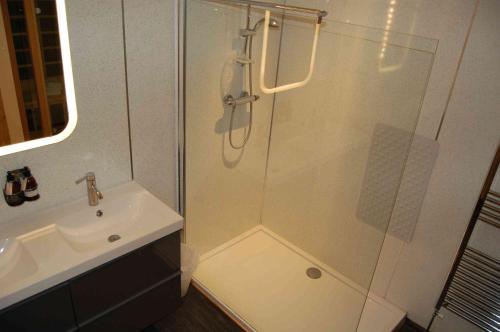 a bathroom with a glass shower and a sink at Waterfall Lodge - private waterfall and sauna in Killin