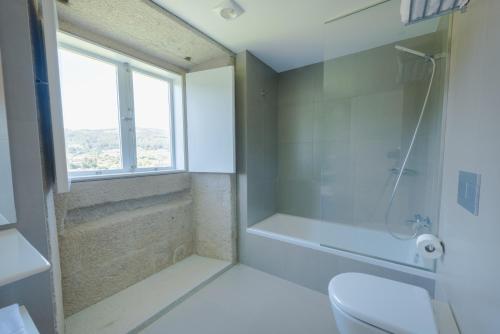 a bathroom with a shower and a toilet and a window at Torre de Tebra in Tomiño