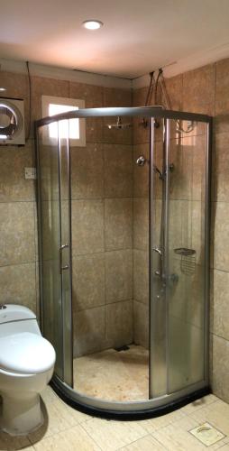 a bathroom with a shower and a toilet at قصر الباحة للشقق المخدومة تصنيف اقتصادي in Al Baha