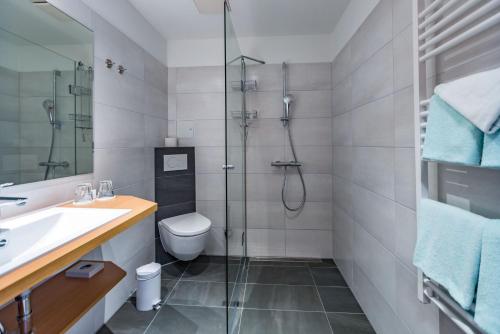 a bathroom with a shower and a toilet and a sink at Am Weststrand Aparthotel Kühlungsborn in Kühlungsborn