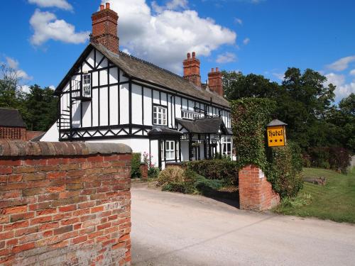 an old black and white building with a for sale sign at Donington Park Farmhouse Hotel in Castle Donington