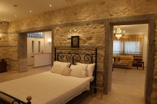 - une chambre avec un lit et un mur en pierre dans l'établissement Villa Vanilla, à Agioi Theodoroi