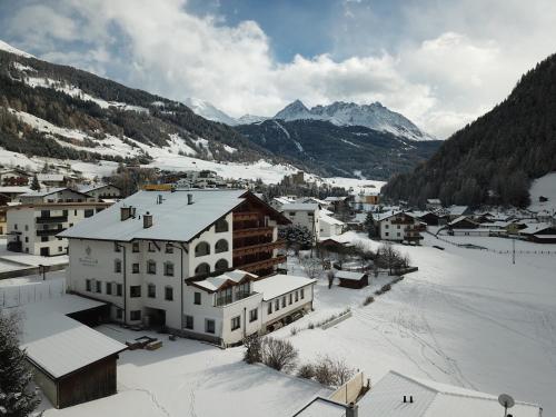 a town in the snow with mountains in the background at Hotel Bergblick in Nauders