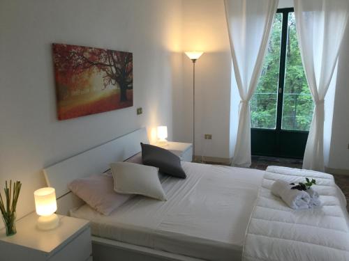 ランダッツォにあるVilla Irene Vagliasindi - Etnaのベッドルーム1室(白いベッド1台、ランプ2つ、窓付)