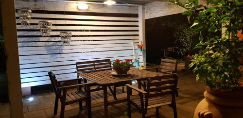 un tavolo in legno e sedie con fiori su un patio di Casale Terra Sole B&B a Terlizzi