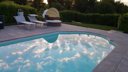 a swimming pool with clouds in the water at Bed & Bistrò Che Piasì in Calamandrana