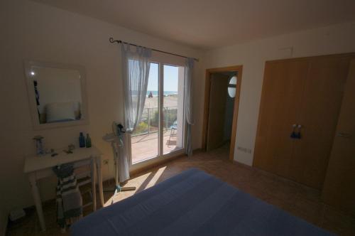 トレリャ・デ・モングリにあるLes Dunes 6060のベッドルーム1室(ベッド1台付)、バスルーム(窓付)が備わります。