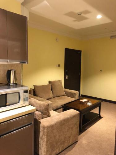 a living room with a couch and a microwave at قصر الباحة للشقق المخدومة تصنيف اقتصادي in Al Baha