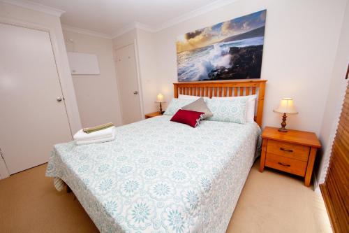 1 dormitorio con 1 cama y una pintura en la pared en Ocean Mist Villa, en Albany