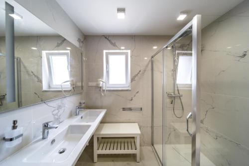 a white bathroom with a sink and a shower at Villa Christian in Malinska