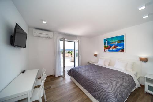 a bedroom with a bed and a desk and a television at Modern Villa Christian with pool, sauna, and jacuzzi, 10 min walk from the beach in Malinska