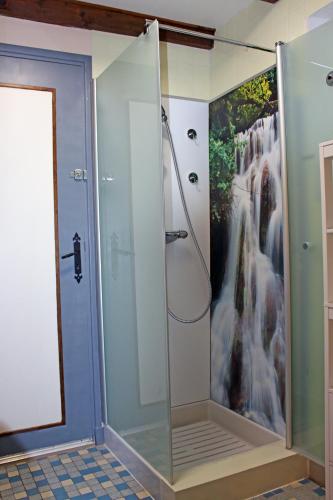 La salle de bains est pourvue d'une douche et d'une peinture représentant une cascade. dans l'établissement La Cascade Fleurie, à Saint-Genès-Champespe