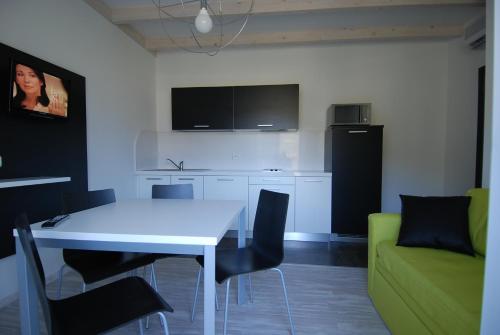 a kitchen with a white table and a green couch at Ecohotel Primavera in Riva del Garda