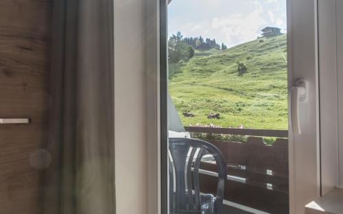 a view of a green hill from a window at Haus Himmelreich in Hirschegg