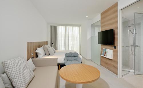 a room with a couch and a bed and a table at INNSiDE by Meliá Calviá Beach in Magaluf