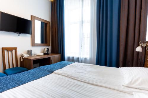 a hotel room with a bed and a desk and a window at Talisman Gorokhovaya in Saint Petersburg