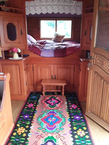 a small room with a bed and a rug at la roulotte de l'ami nature in Barrais-Bussolles