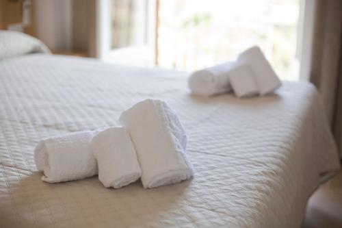 two stacks of towels on a white bed at Donna Rosa Accommodation in Tropea