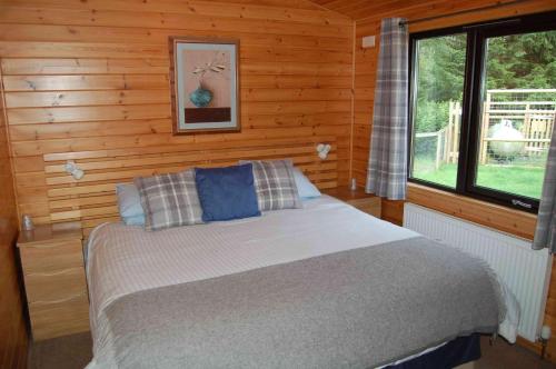 Rúm í herbergi á Luxury woodland Alder Lodge