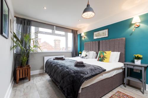 Un dormitorio con una cama grande con paredes azules. en Accudo House Boutique Holiday Suites, en Portsmouth
