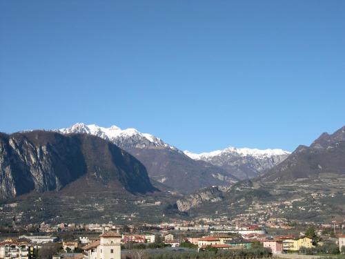 a city with snow capped mountains in the background at Ecohotel Primavera in Riva del Garda
