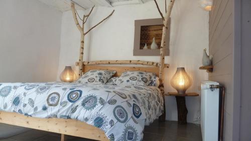 a bedroom with a bed with a blue and white comforter at Fenêtre sur Loire in Iguerande