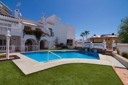 a villa with a swimming pool in front of a building at BAJAMAR II 22 MENYBER in Nerja