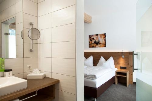 ザンクト・アントン・アム・アールベルクにあるAlpenlebenのベッドとバスルーム付きのホテルルームです。