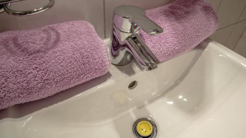 a sink with a purple towel and a faucet at Haus Himmelreich in Hirschegg