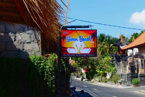 a sign for a snack bar on the side of a street at Swan Beach Inn in Nusa Penida