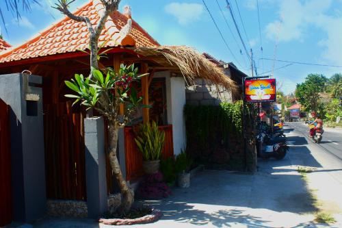 a small red building with a sign in front of it at Swan Beach Inn in Nusa Penida