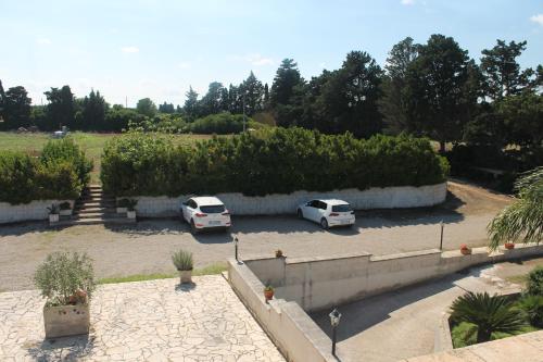 two white cars parked in a parking lot at Tenuta Turchi in Otranto