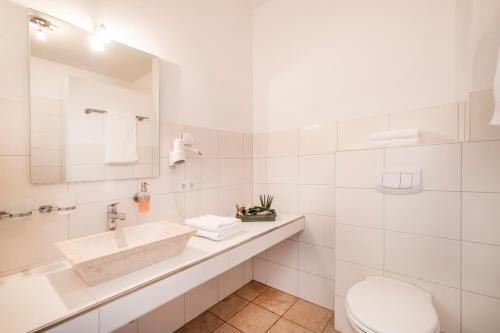 
a bathroom with a sink, toilet, and bathtub at Hotel Pharisäerhof- Nordseeurlaub mit Hund in Nordstrand
