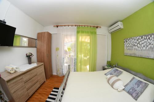 a bedroom with a bed and a green wall at Apartments Marcela in Stari Grad