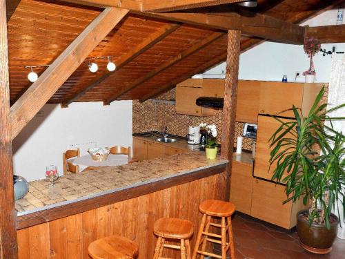 a kitchen with a counter and stools in a room at Ferienstudios Weindl in Sankt Englmar