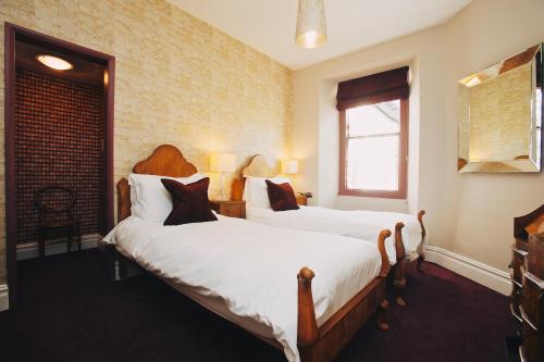 a bedroom with two beds and a window at Rum Doodle, Windermere B&B in Windermere