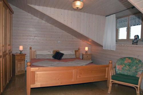 1 dormitorio con cama de madera y silla en Ferienstudios Weindl en Sankt Englmar