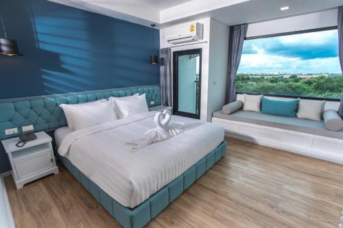 a bedroom with a bed and a large window at Haus Hotel Udonthani in Udon Thani