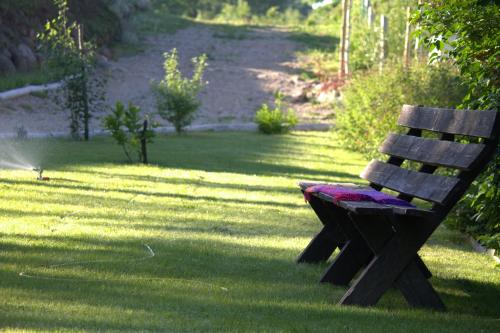 a wooden park bench sitting in the grass at Szwajcaria Mazurska in Zawady Oleckie