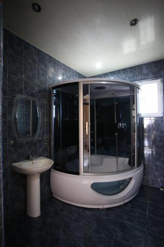 a bathroom with a large shower and a sink at Talo's Guest House in Makhinjauri