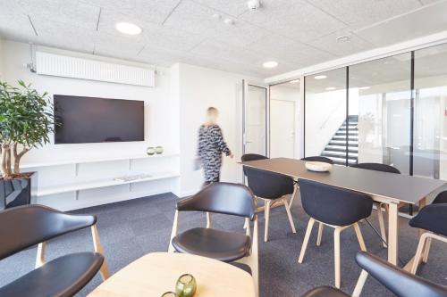 an office with a table and chairs and a tv at athome apartments in Aarhus