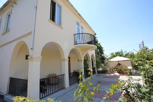 a house with a balcony and a table and a tent at Talo's Guest House in Makhinjauri