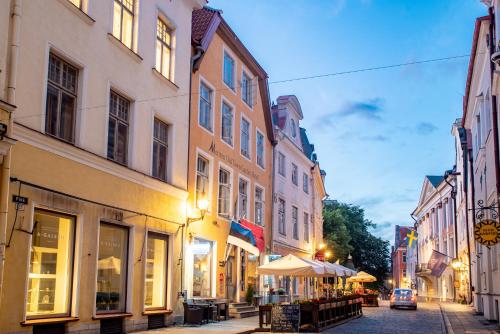 a city street with buildings and a street with tables and umbrellas at Meriton Old Town Garden Hotel in Tallinn