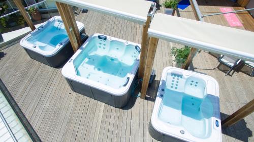 two jacuzzles on a balcony with two sinks at Georgioupolis Beach Hotel in Georgioupolis