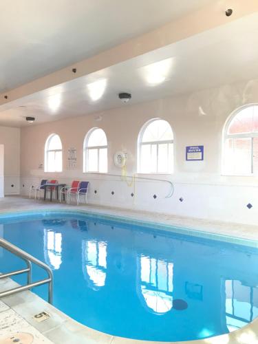 a large swimming pool with blue water in a building at Americas Best Value Inn and Suites Saint Charles in St. Charles