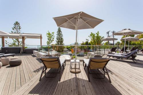 a patio with a table and chairs and an umbrella at Georgioupolis Beach Hotel in Georgioupolis