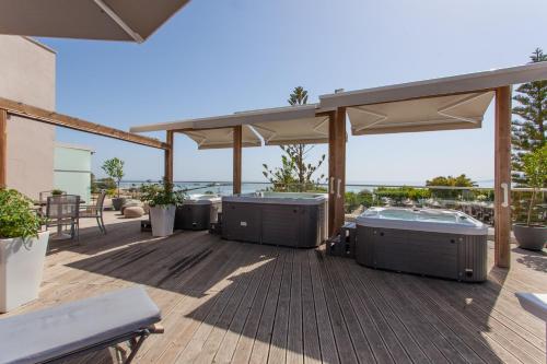 a patio with two hot tubs on a deck at Georgioupolis Beach Hotel in Georgioupolis